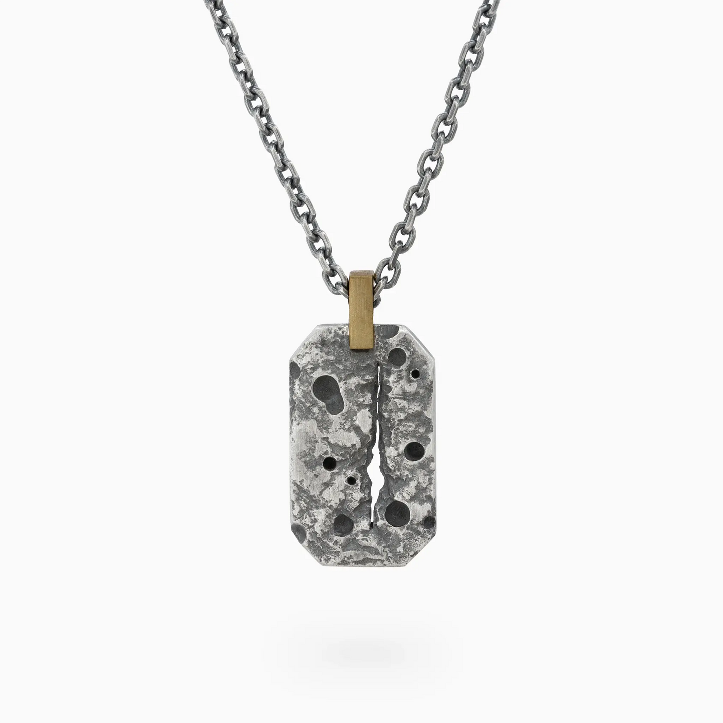 Oxidized sterling silver ISRT pendant with textured surface, central crack design, and gold bail on a silver chain.