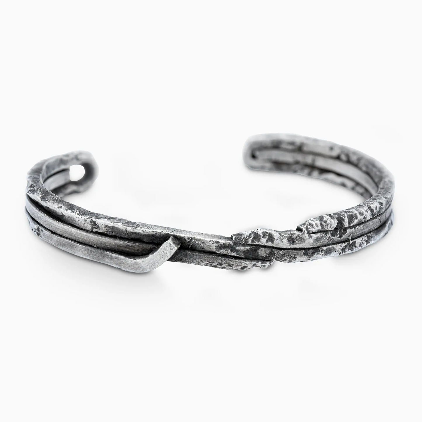 Handcrafted silver bracelet with textured design and intertwined elements.