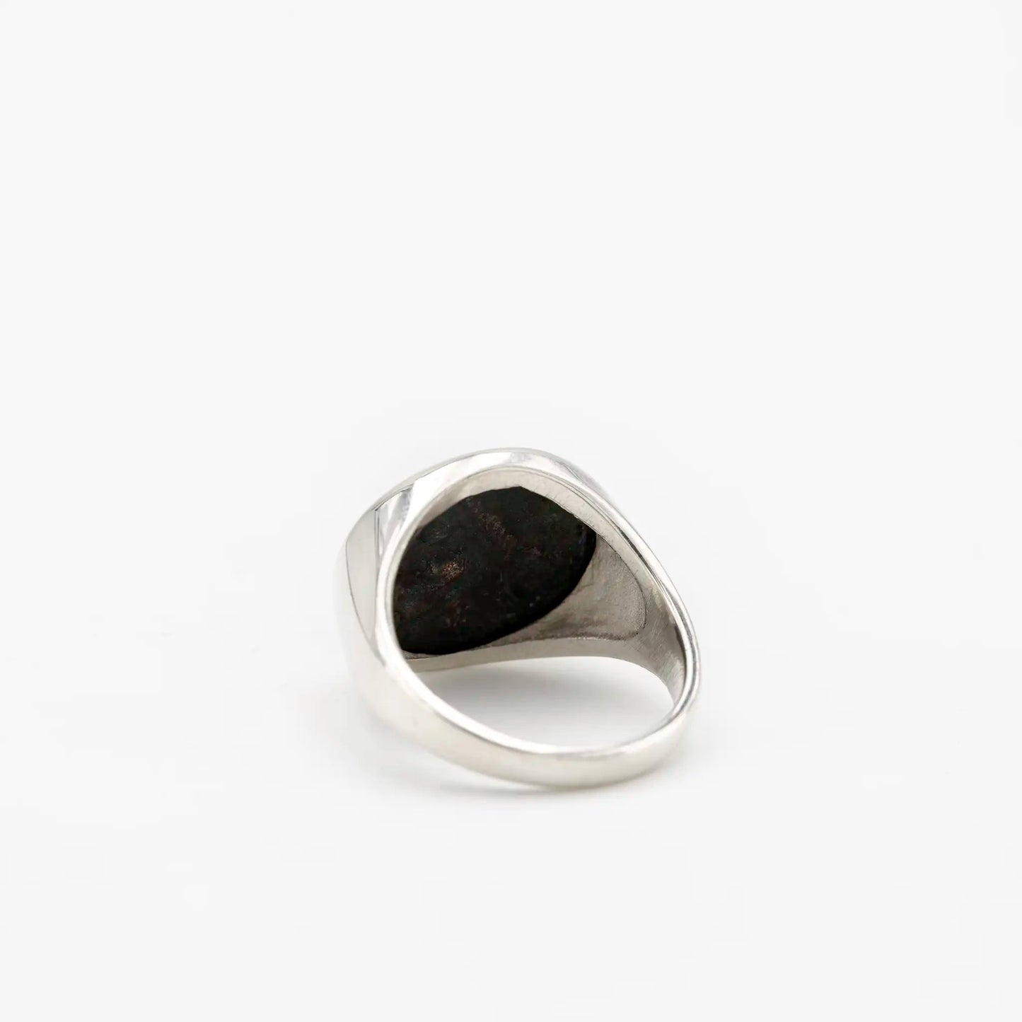 Back view of a silver signet ring with an inset antique coin, showing smooth polished inner band.