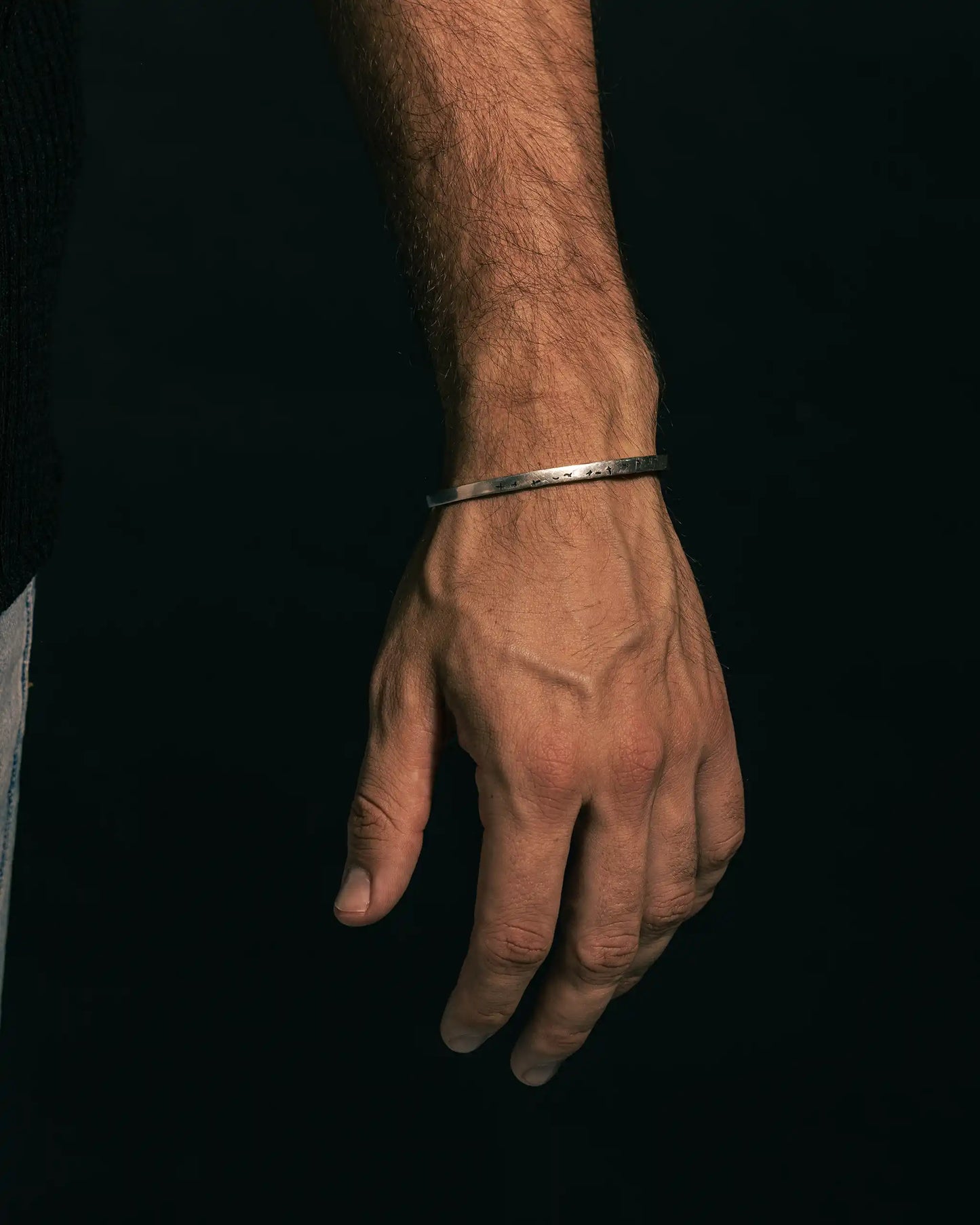 Minimalist 925 silver Birds Echelon bracelet on a man’s wrist, featuring an open cuff design and lightweight style.