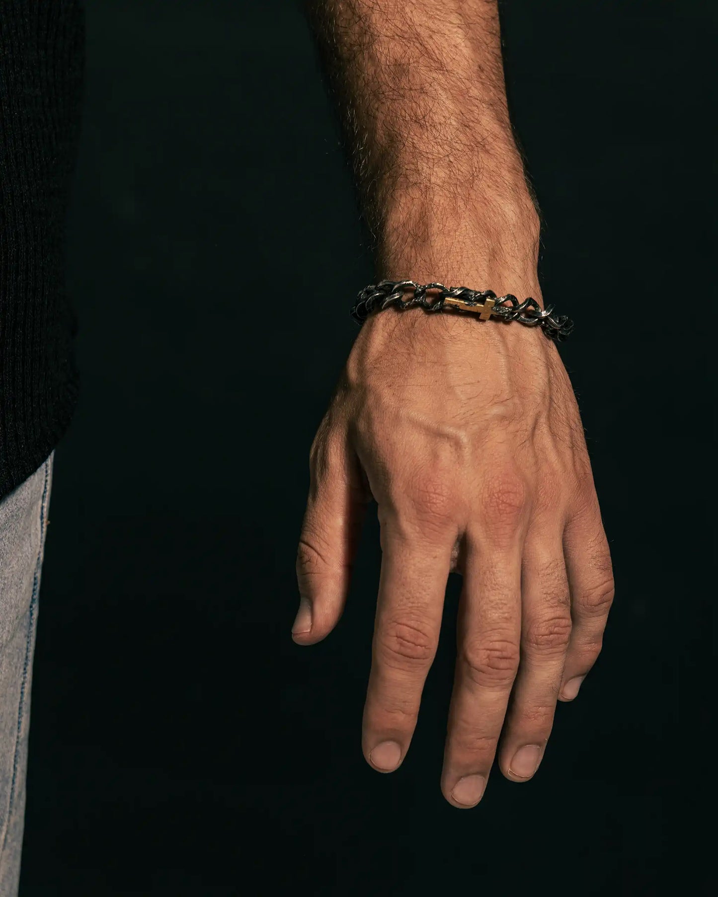 Bold handcrafted bracelet with textured silver links, gold cross accent, and toggle clasp.