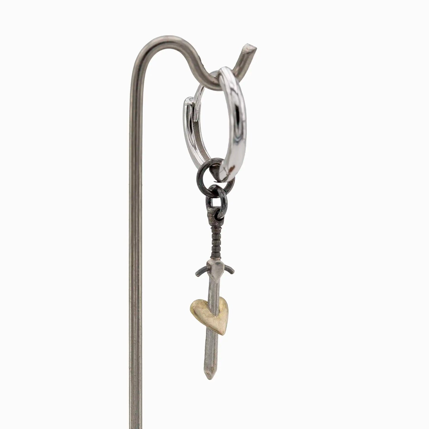 Side view of silver hoop earring with gold-plated heart sword charm.