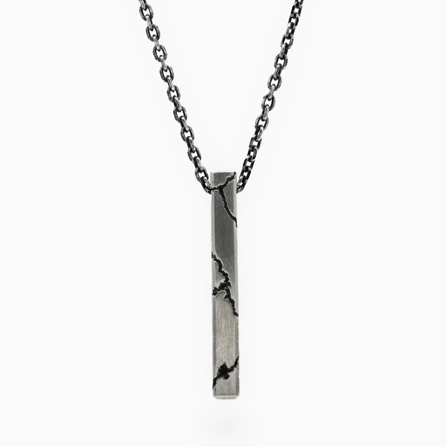 Sterling silver lightning-inspired pendant with bold cracked details on a dark chain, blending urban edge and refined crafts…