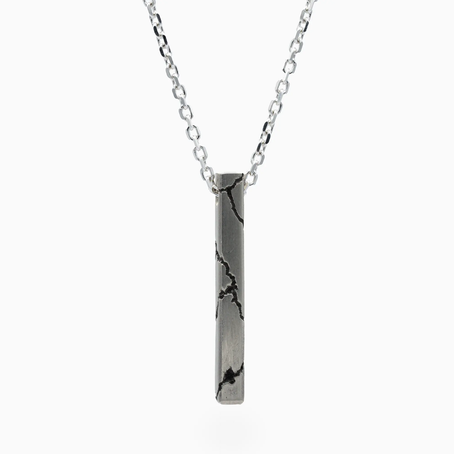 Lightning-themed pendant with bold textured details on a light silver chain.