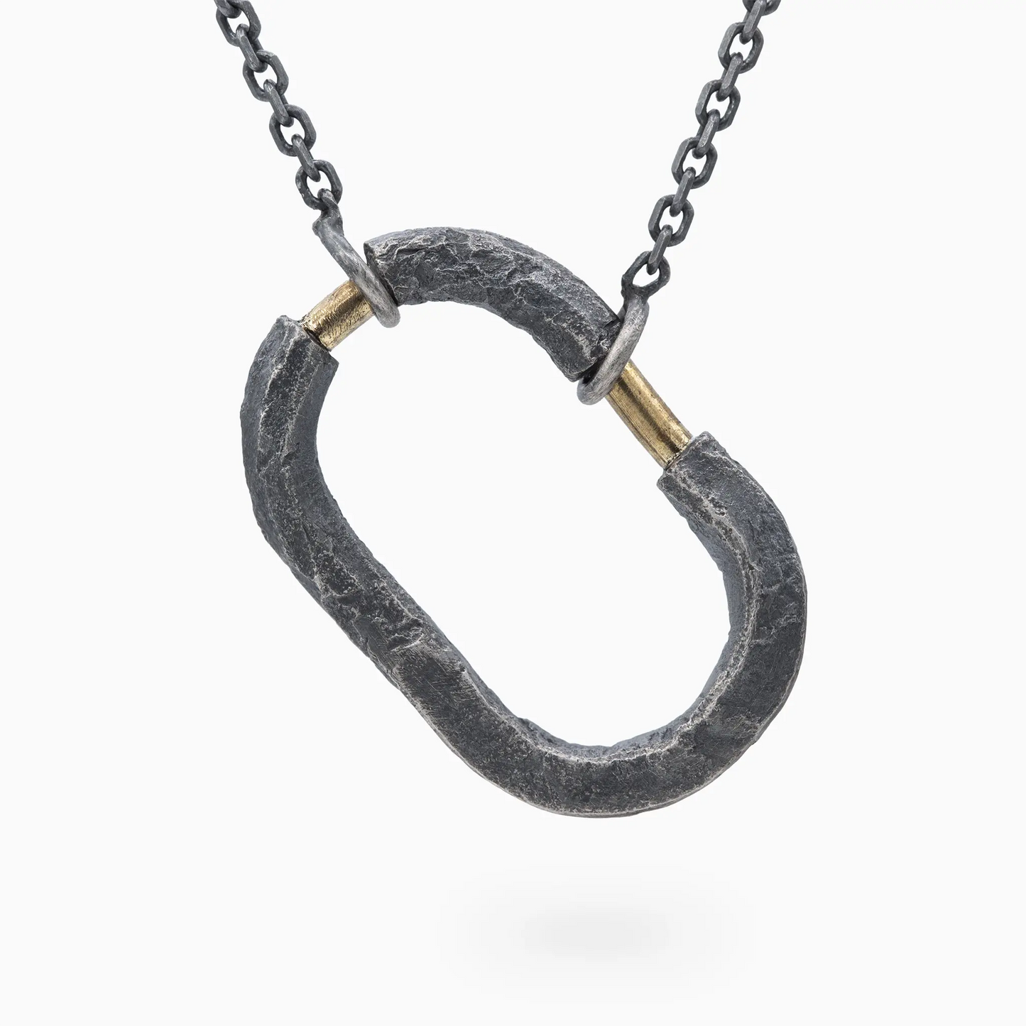 Oxidized silver pendant with gold accents, rugged texture, symbolizing strength and connection.