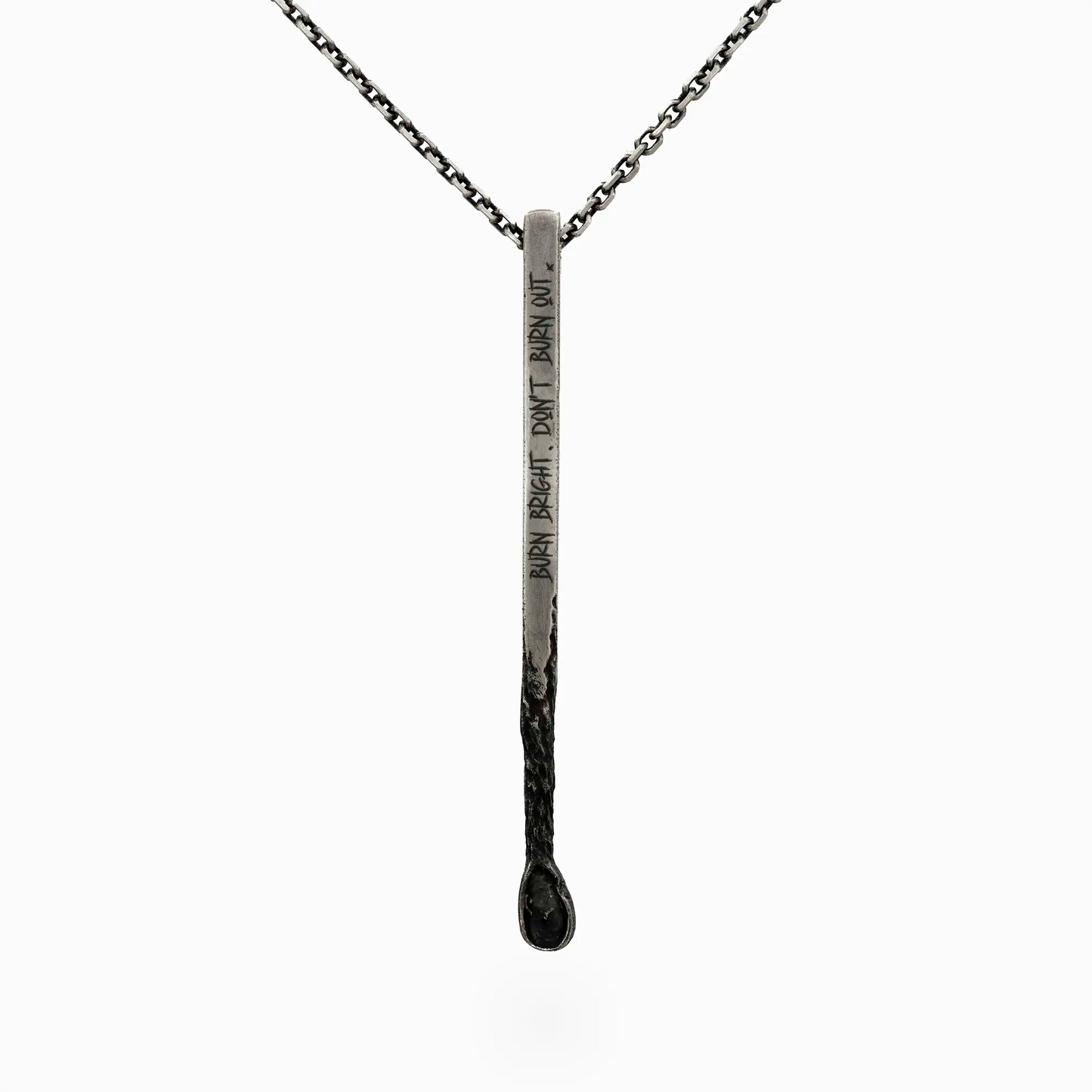 Silver matchstick pendant engraved with 'Burn Bright, Don’t Burn Out,'.