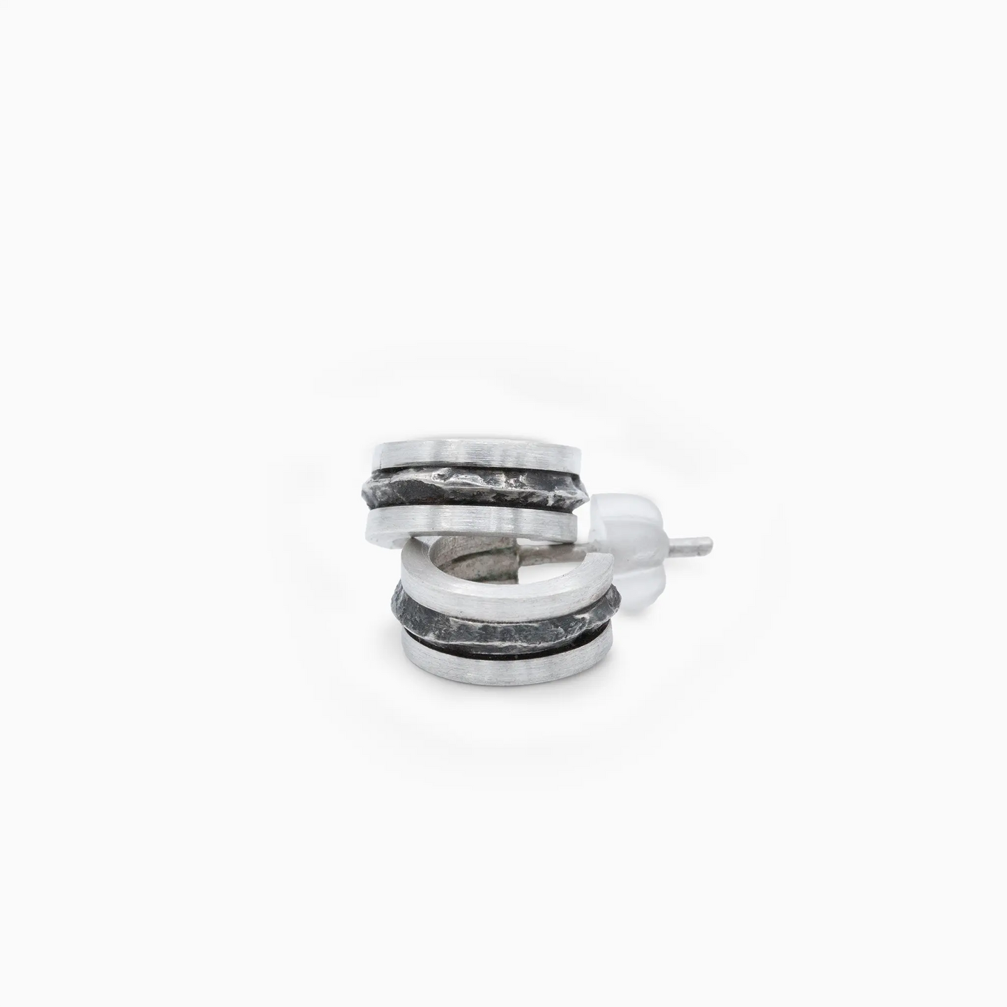 Silver hoop earrings with smooth and textured surfaces, blending contemporary and nature-inspired design.