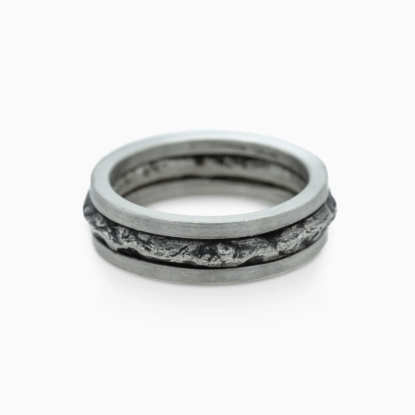Silver ring with rugged, textured mountain-inspired design.