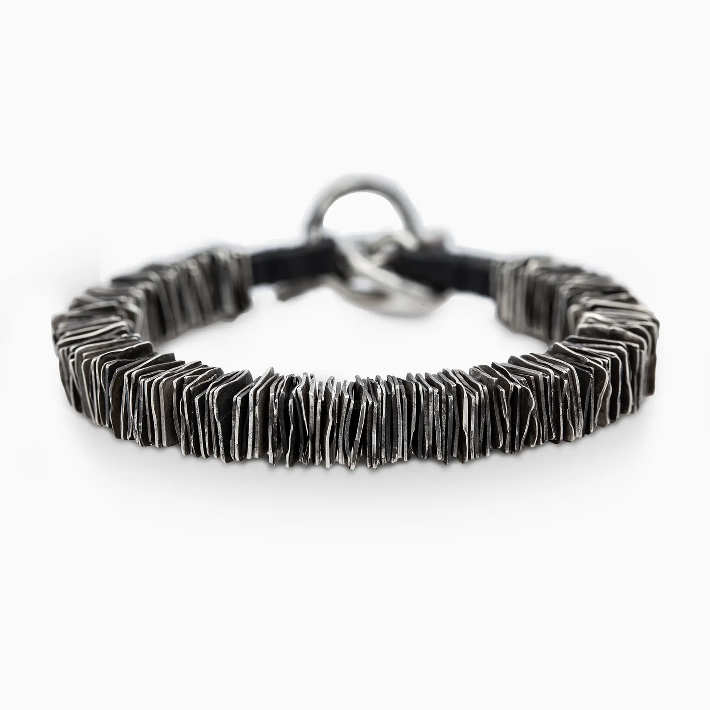 Overhead view of the 'Plates' bracelet, featuring layered silver design for a bold, artful statement.