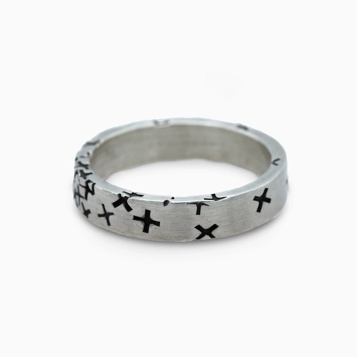 Silver ring with black cross motifs around the band.