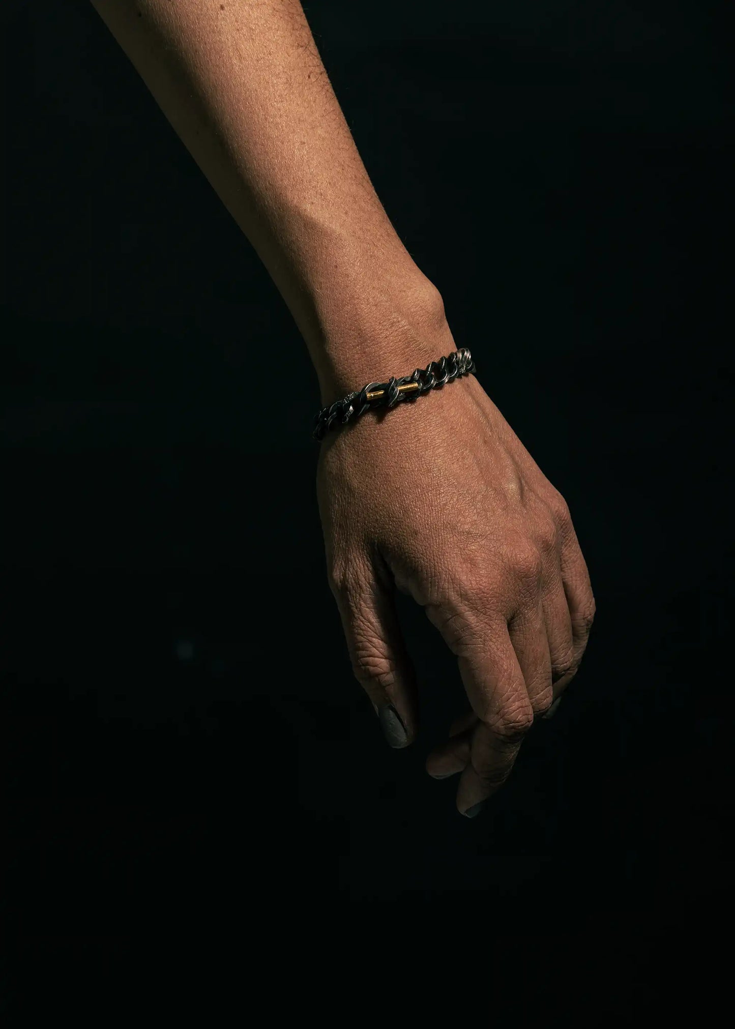 A full arm view showcasing the Staff and Chain bracelet in oxidized silver, featuring a modern, minimalist design.