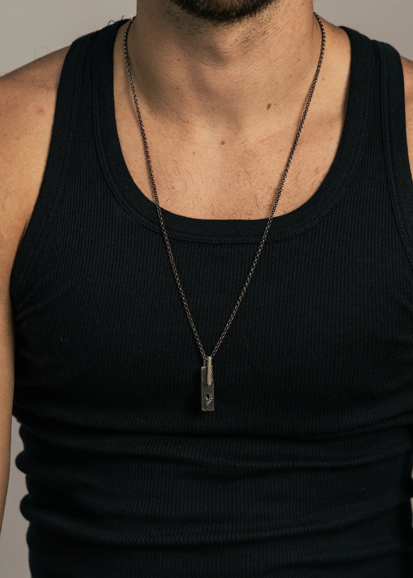 Man wearing a silver SW-0801 pendant on a chain, highlighting its bold design and craftsmanship.