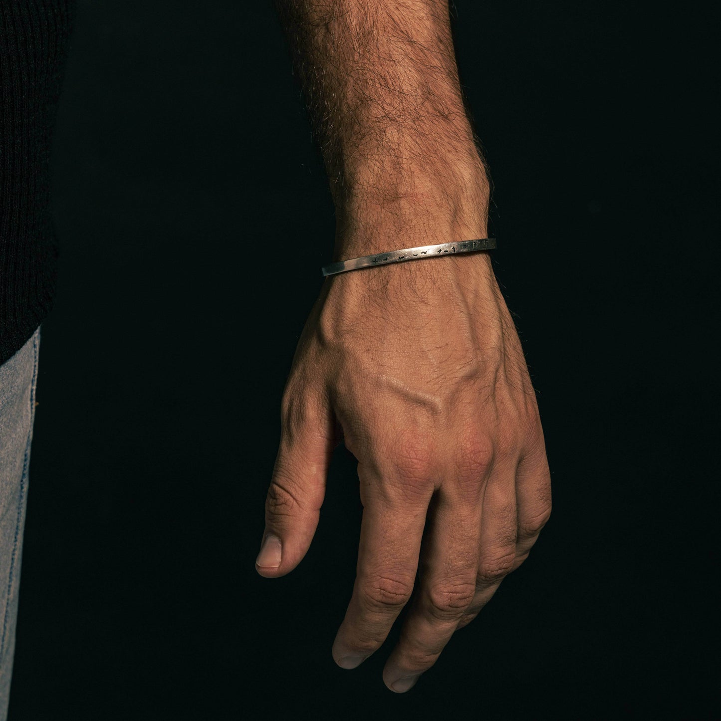 Minimalist 925 silver Birds Echelon bracelet displayed on a man's wrist, showcasing its open cuff design and lightweight appeal.