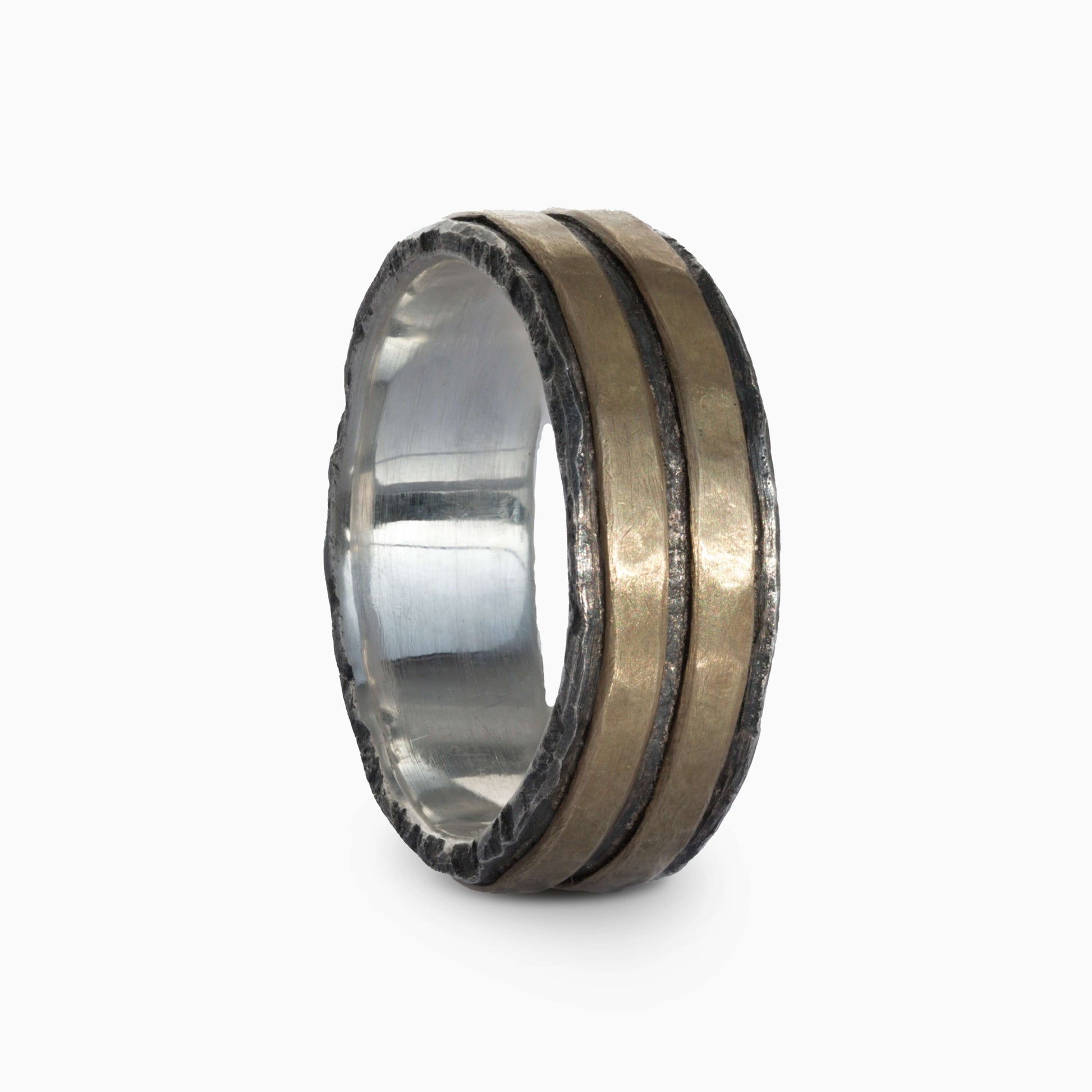 Silver and brass ring with bold parallel lines and rugged edges. A modern, textured design blending strength and elegance.