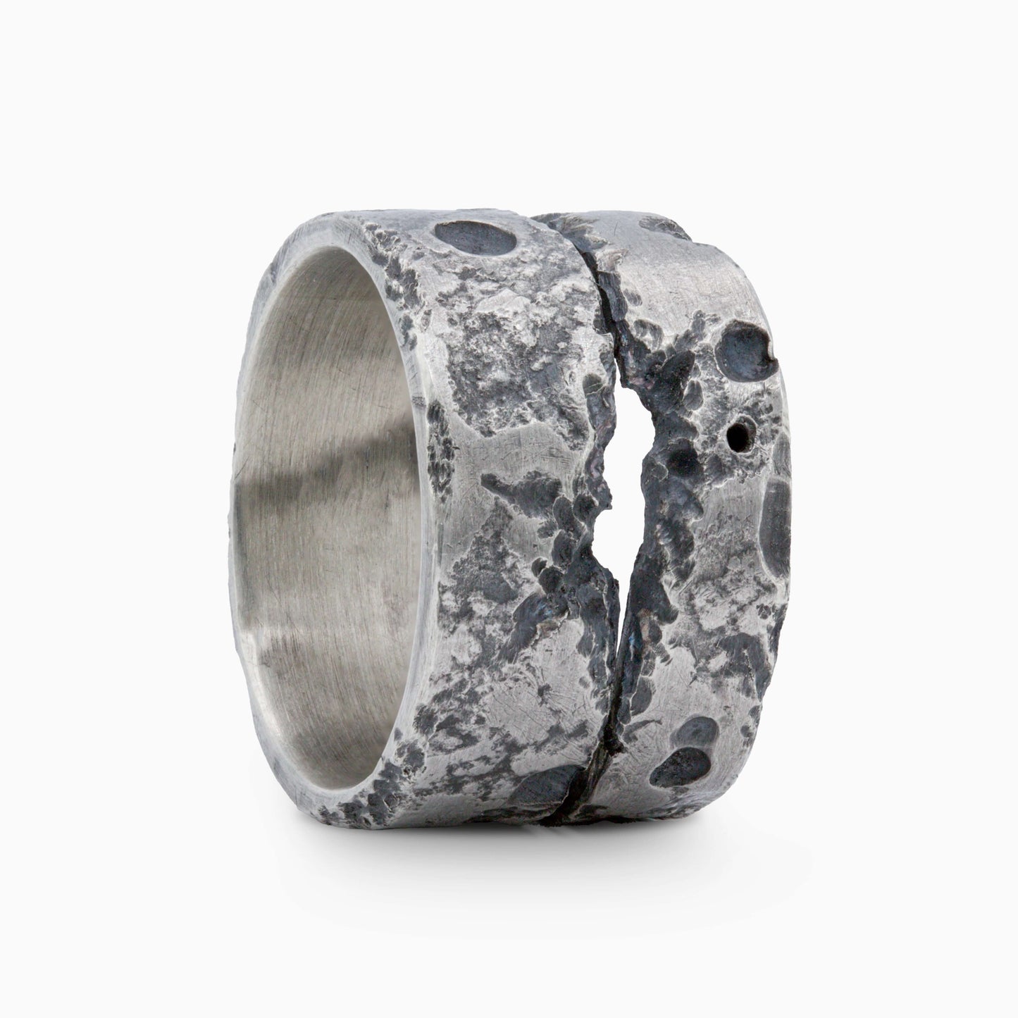 Silver ring with rugged, textured details and a bold central crack. A statement piece combining raw elegance and contemporary design.