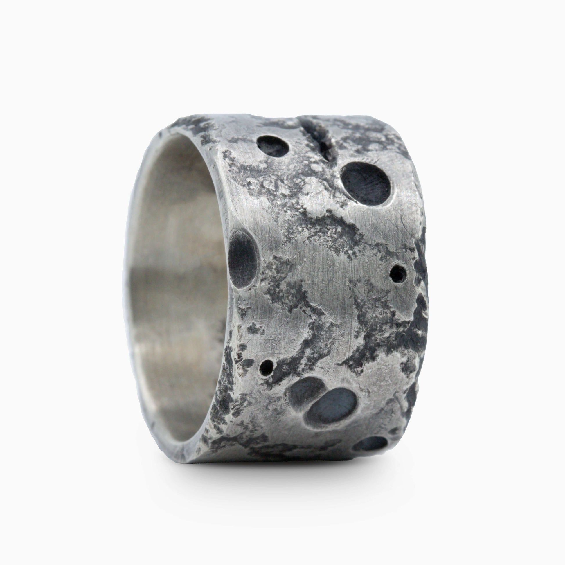 Silver ring featuring rough, crater-like textures and intricate surface details. A unique design that exudes modern artistry.