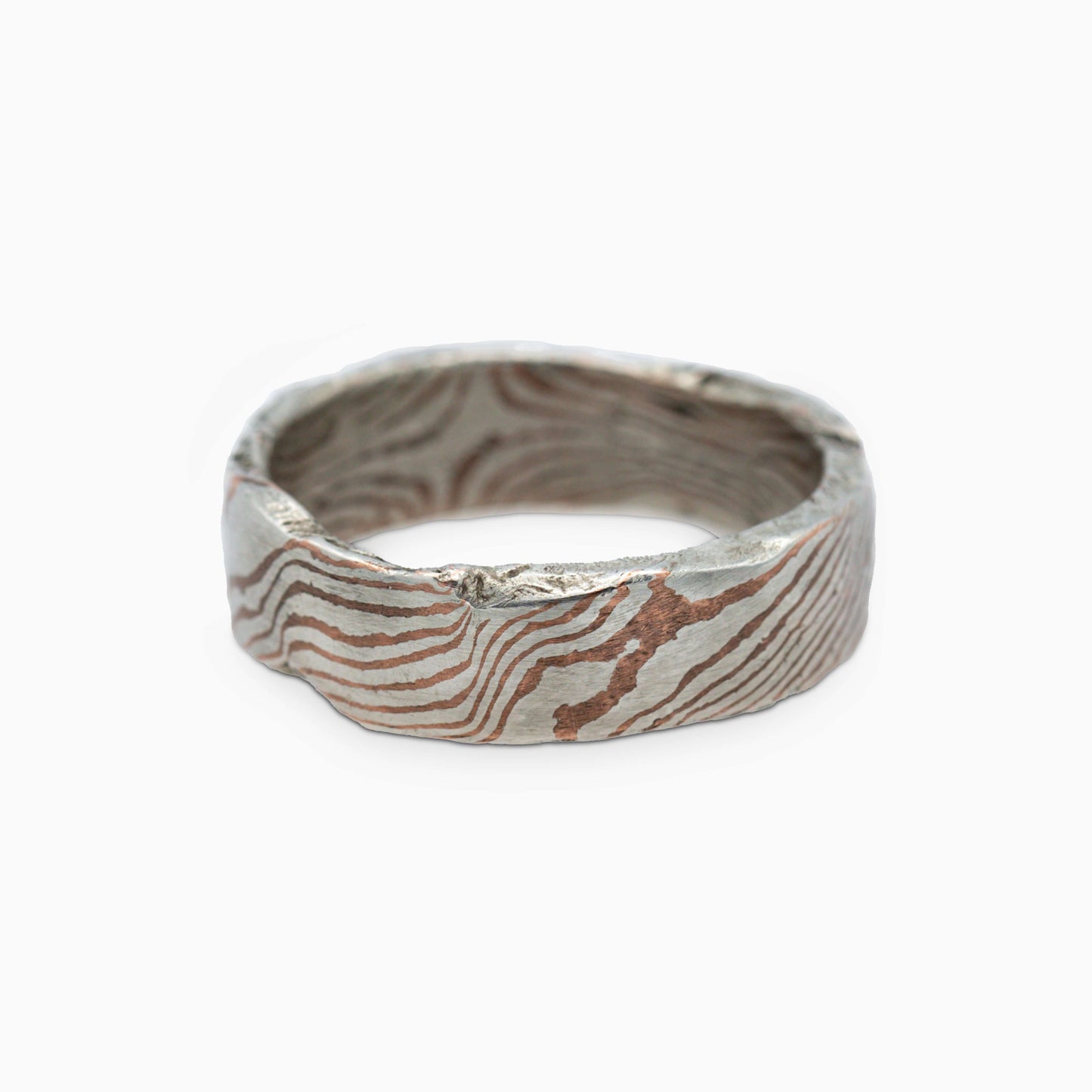 The Moku Ring lying flat, highlighting its flowing mokume-gane pattern with delicate layers of metals blending seamlessly.