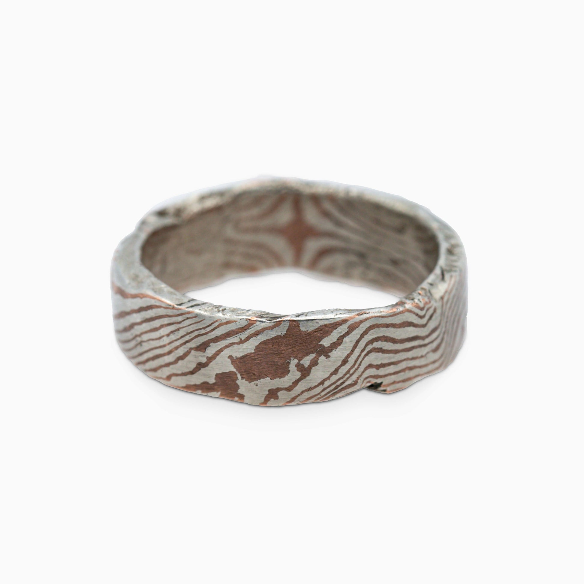 A side view of the Moku Ring, displaying its dynamic texture and metallic layers that evoke timeless artistry.