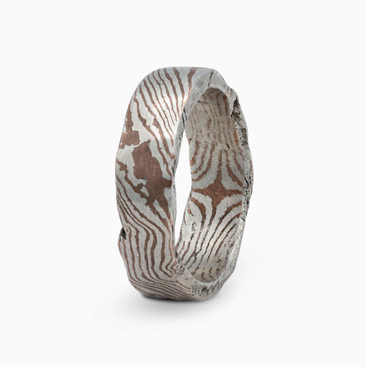 The Moku Ring standing upright, showcasing the mesmerizing blend of metals and elegant, handcrafted details.