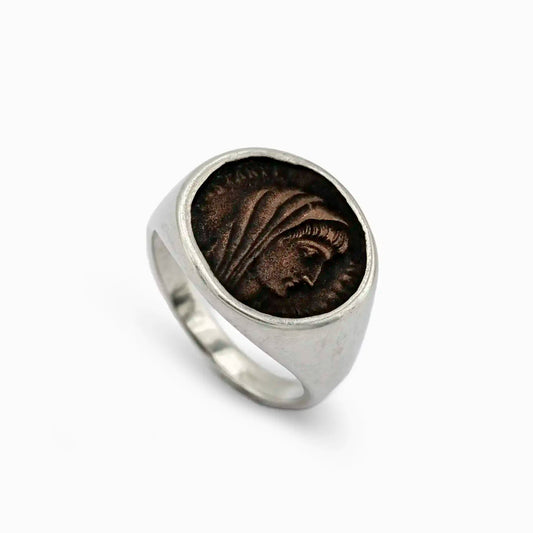 Silver signet ring with dark bronze coin depicting a hooded profile in fine relief.