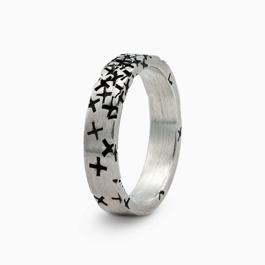 Detailed view of a silver ring with textured black crosses, showcasing its bold and artistic design for a distinctive statement look.