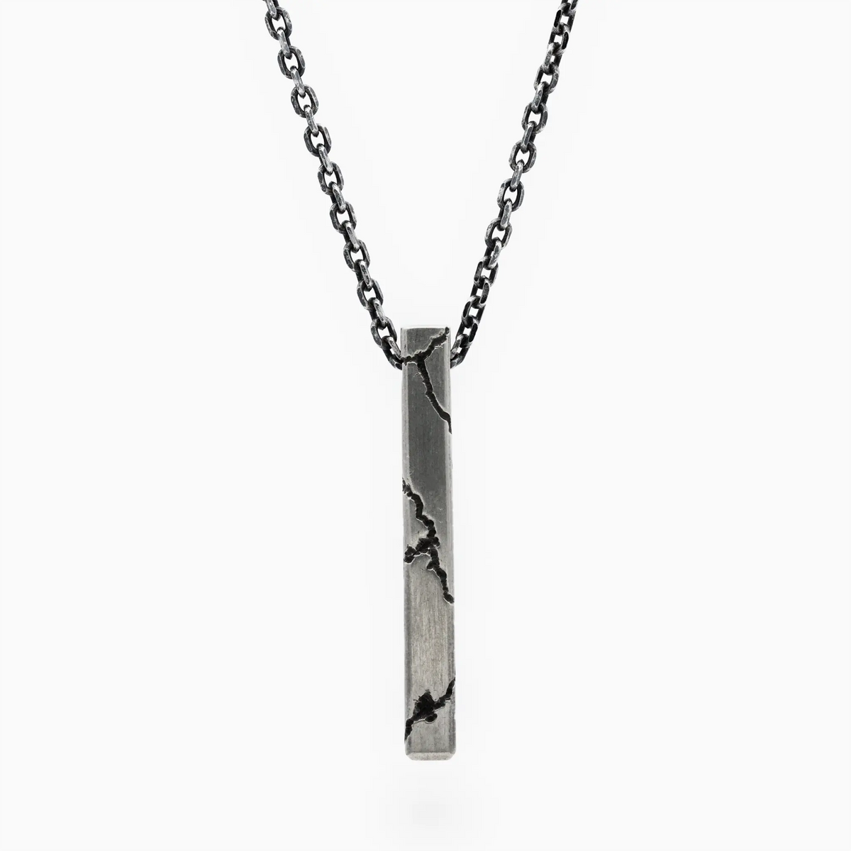 Sterling silver lightning-inspired pendant with bold cracked details on a dark chain, blending urban edge and refined crafts…