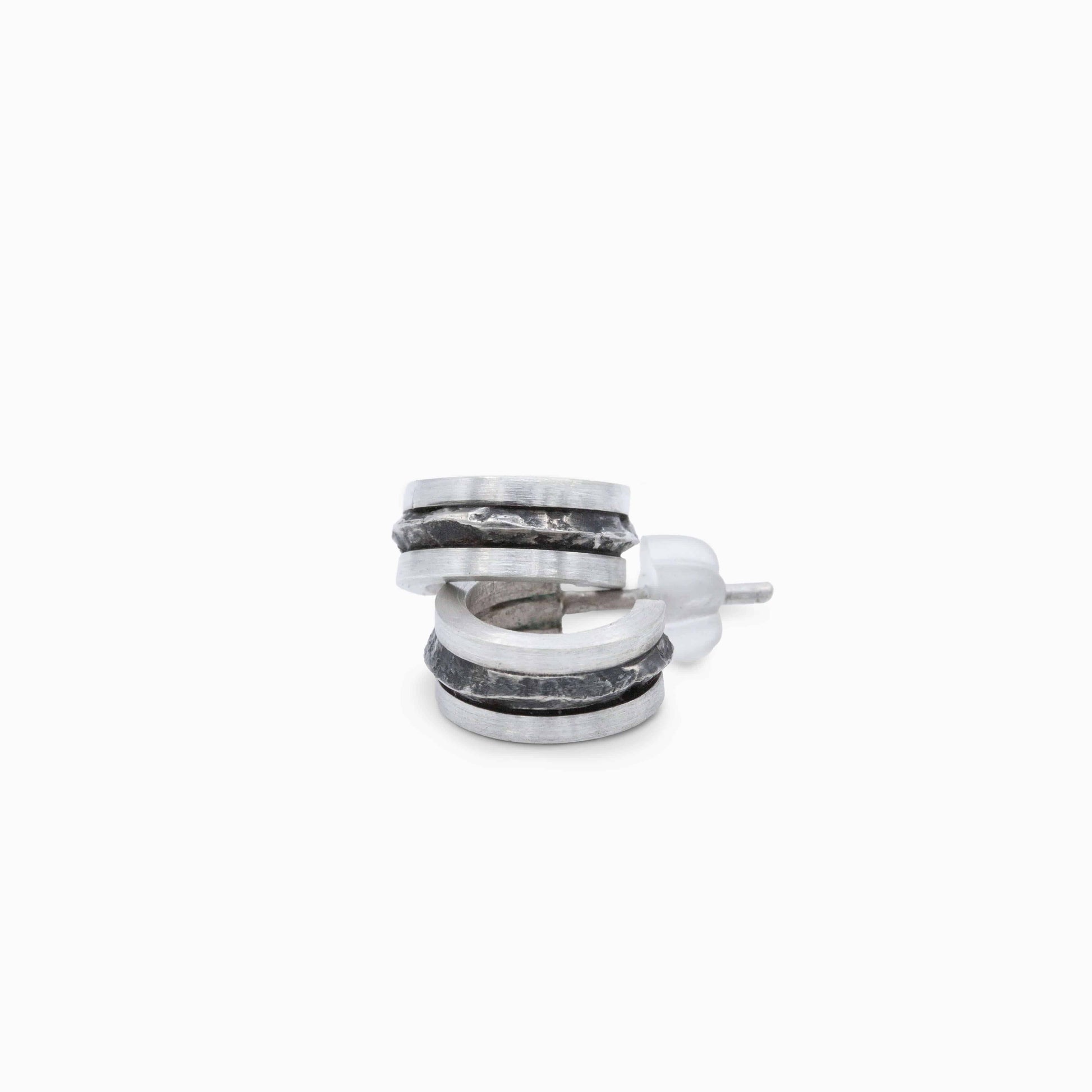 Silver hoop earrings showcasing a mix of smooth and textured surfaces. A contemporary, nature-inspired design with refined elegance.